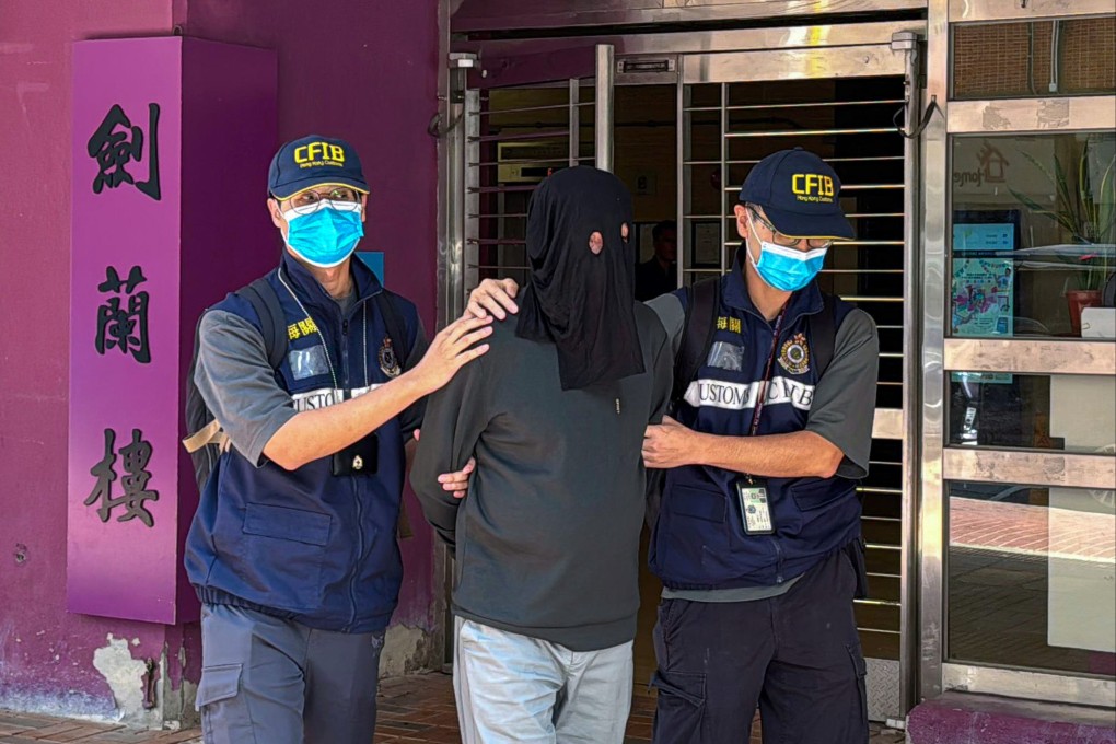 Hong Kong customs officers lead away a suspect in a HK$1.6 billion money laundering case in October. Hong Kong is hard at work combating money laundering, which relies on international cooperation to be effective. Photo: Handout