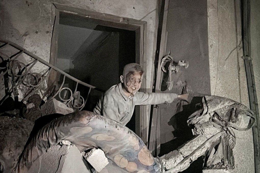 A child looks on following an Israeli strike at a post office where people were sheltering in the central Gaza Strip on December 12. Photo: Reuters