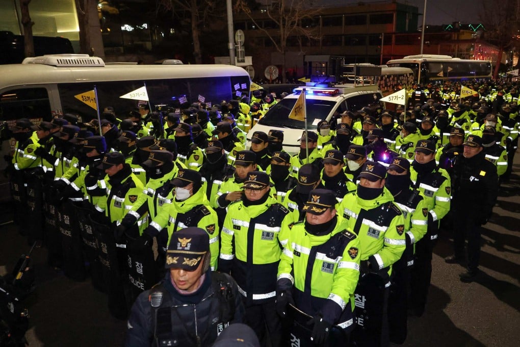 Police stand guard at the entrance of the presidential office in Seoul as people take part in a protest calling for the ouster of South Korean leader Yoon Suk-yeol on December 12. Photo: Yonhap/AFP