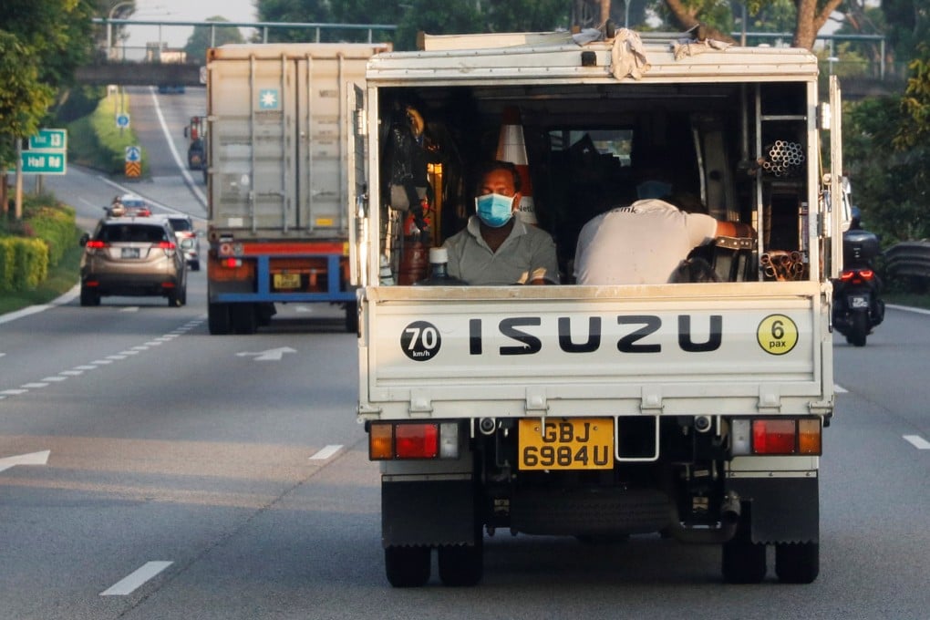Migrant workers sit in the back of a truck in Singapore. Photo: Reuters