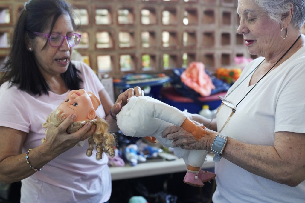 Volunteers discuss the best way to restore a doll at the Hospital for Soft Toys in Venezuela, which fixes old toys to distribute to hospitals, schools in poor areas, and lonely old people in the economically strained country. Photo: AP