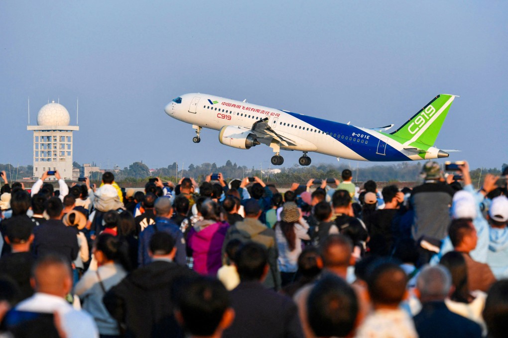 A crowd watches as China’s domestically produced C919 passenger jet takes off at an air show in November. Photo: AFP