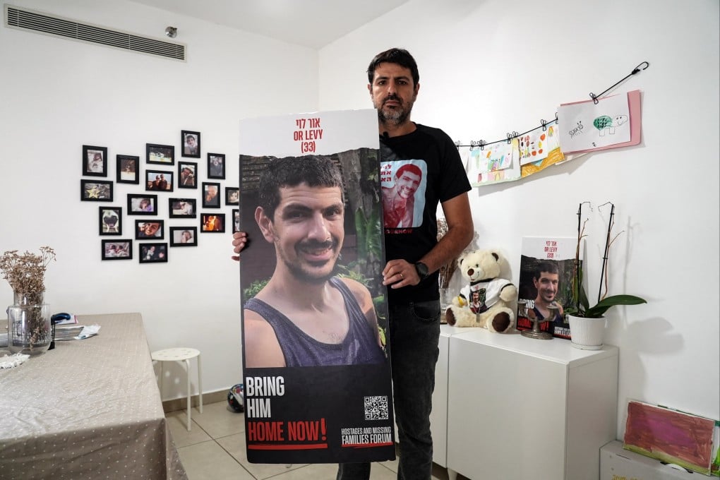 Michael Levy, the brother of Or Levy, 34, who has been held hostage in Gaza since he was abducted during last year’s attack by Hamas, holds a poster of Or during an interview on Tuesday. Photo: Reuters
