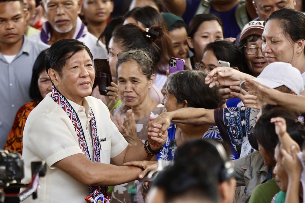 Philippine President Ferdinand Marcos Jnr shakes hands with residents during the distribution of food aid in Manila on December 14. Photo: EPA-EFE