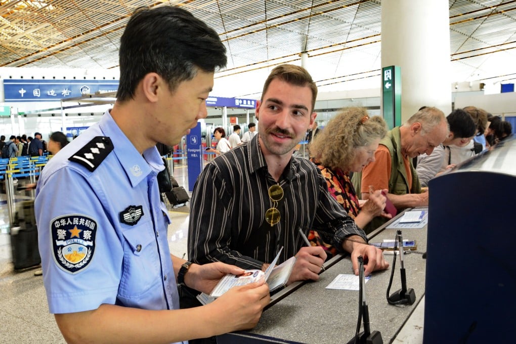 A Chinese police officer helps an American visitor fill in an entry registration card, at the Beijing Capital International Airport in July. Photo: Xinhua