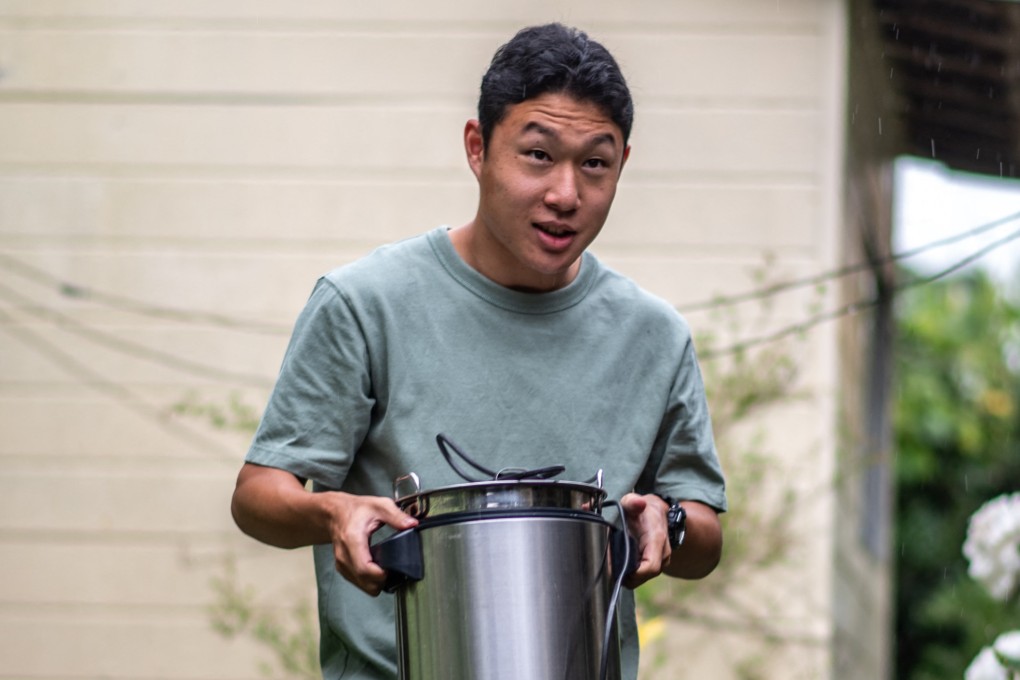 Koichi Miyatsu carries a pot as he prepares to transport meals from his home to a church as part of a monthly charity event for underprivileged children in Kumamoto, Japan, on March 11, 2022. Photo: AFP
