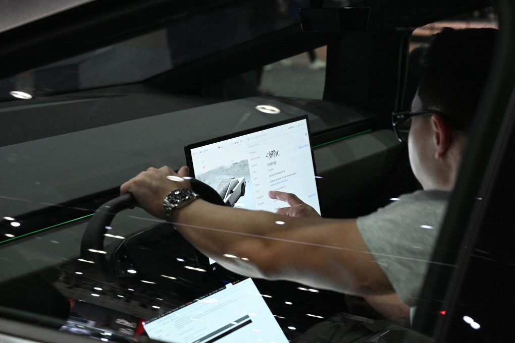 A driver the touchscreen controls in a Tesla Cybertruck during the AutoMobility LA 2024 auto show in Los Angeles. Automotive operating systems are assuming greater importance. Photo: AFP