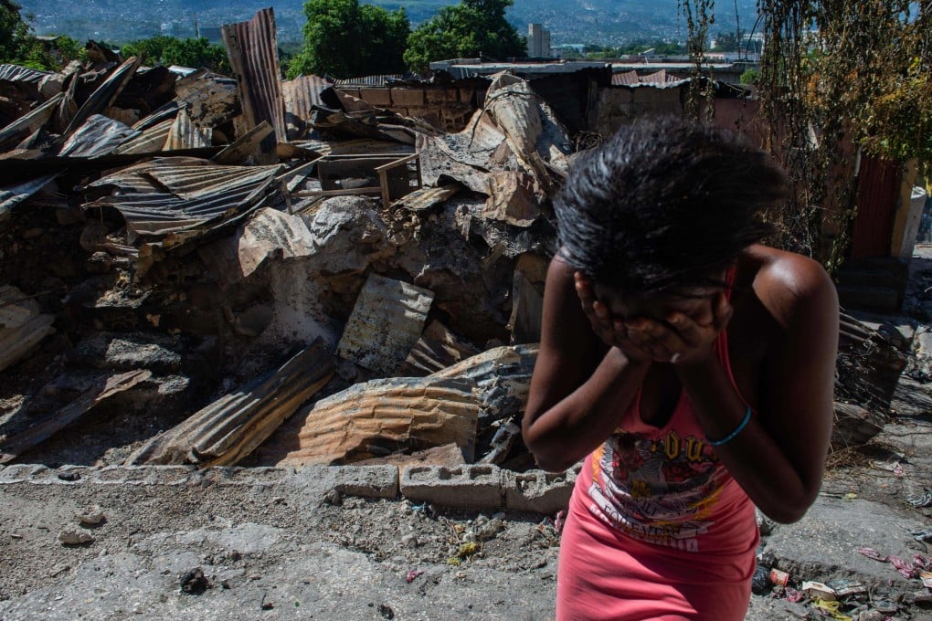 A woman cries outside her house after armed gangs set it on fire in the Post Marchand neighbourhood of Haiti’s Port-au-Prince on December 17. Photo: AFP