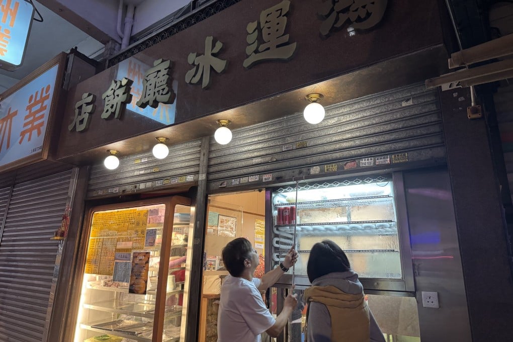 The owner of Hung Wan Cafe pulls down its metal shutters for the last time on Christmas Day. Photo: Jiang Chuqin