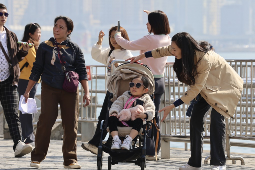 People gather along the Tsim Sha Tsui waterfront. With the monsoon moderating early next week, temperatures are due to climb back up to between 16 and 21 degrees Celsius. Photo: Jelly Tse