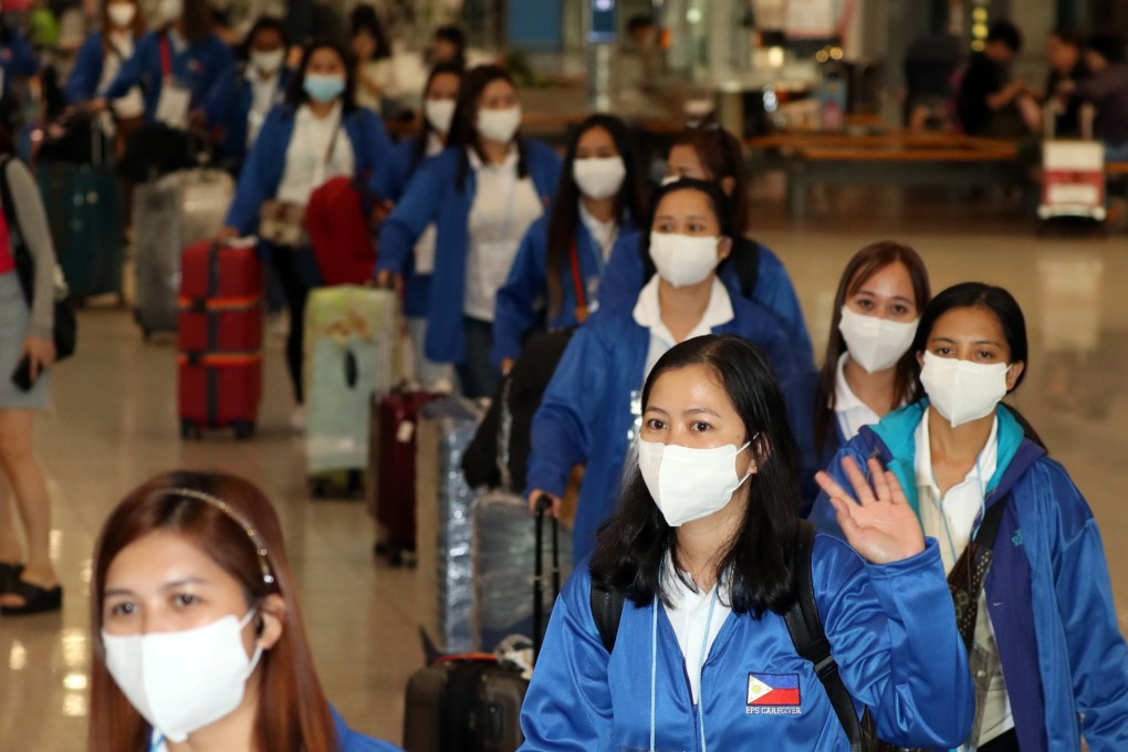 A group of 100 Filipino women at Incheon International Airport in Seoul. They are among a batch hired under a foreign domestic worker pilot programme. Many say the high cost of living prevents them saving money. Photo: EPA