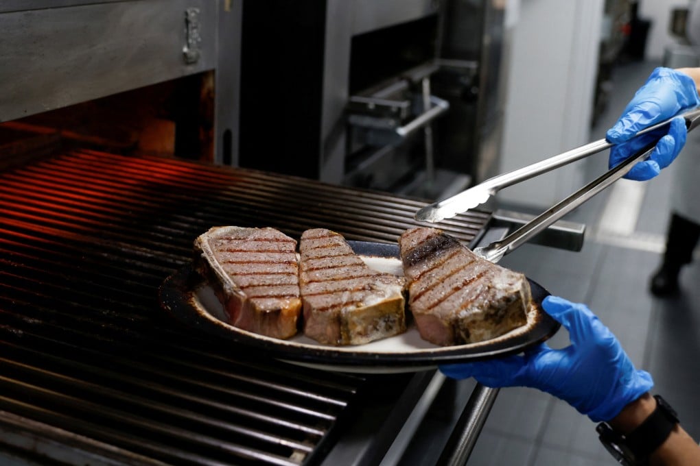 A chef cooks beef steaks at Wolfgang’s Steakhouse in Beijing. Photo: Reuters