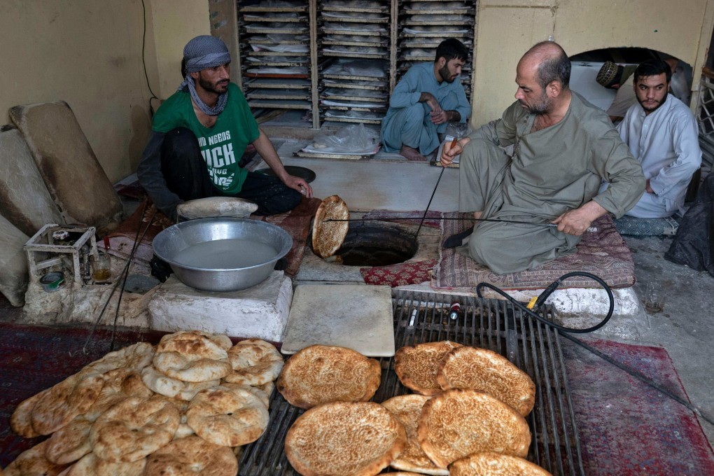 Afghan baker Jamil Ghafori (left) and his  staff preparing traditional flatbreads, called naan, at a bakery in Kabul. For many in Afghanistan , bread makes up the largest part of their meals. Photo: AFP