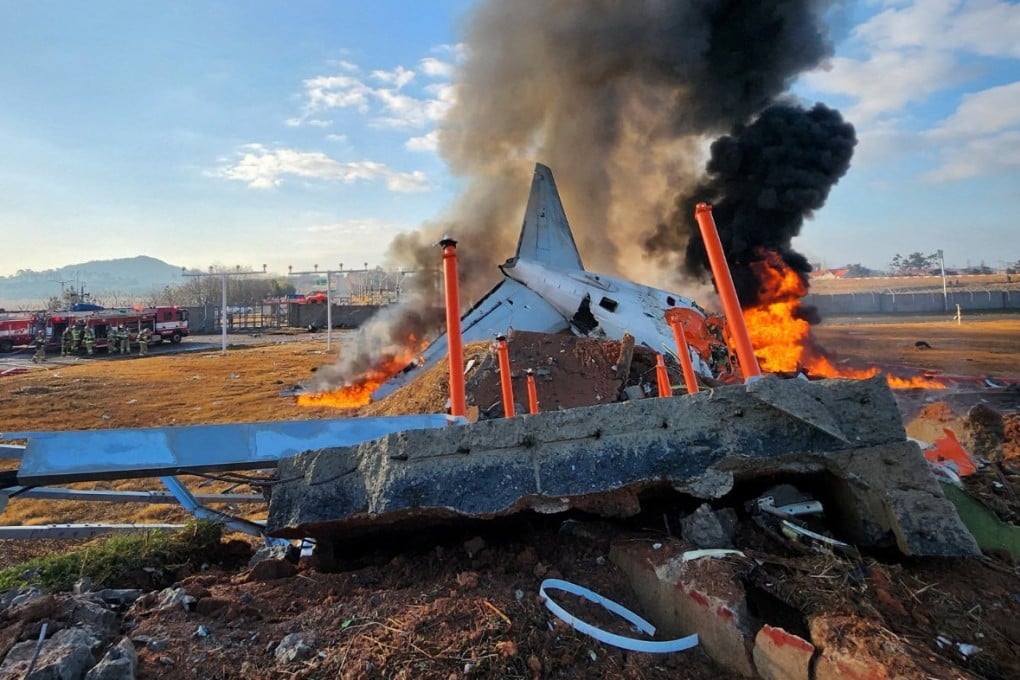 Firefighters carry out extinguishing operations on an aircraft which drove off runaway at Muan International Airport in Muan. Photo: Reuters