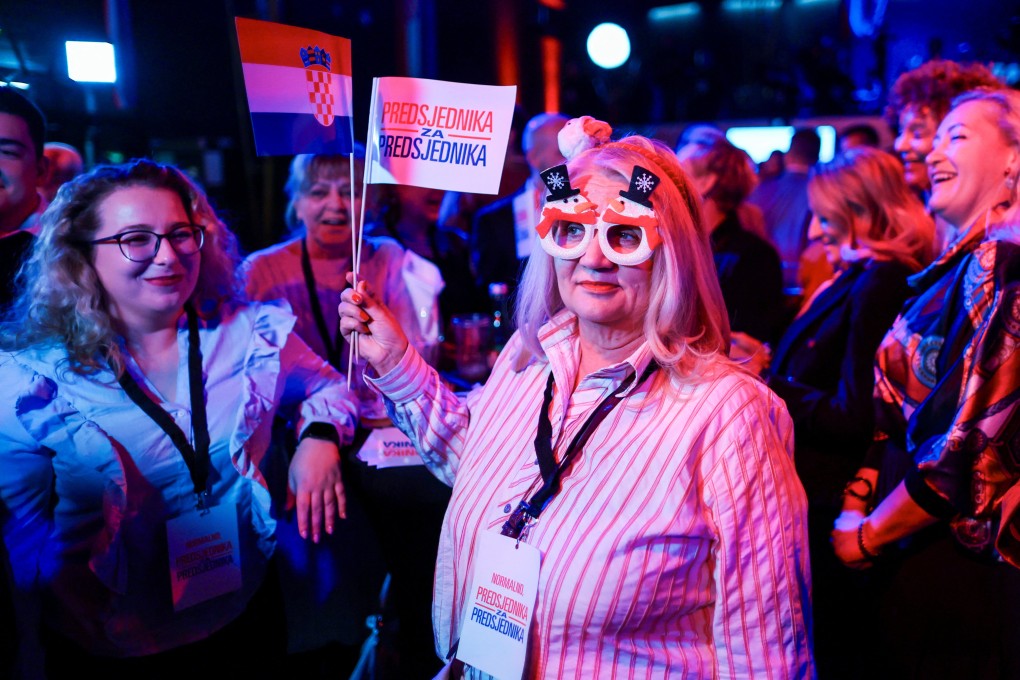 Supporter of Croatian President and presidential candidate Zoran Milanovic hold flags after the first unofficial results of Croatia’s presidential election were announced in Zagreb, Croatia on Sunday. Photo: Reuters