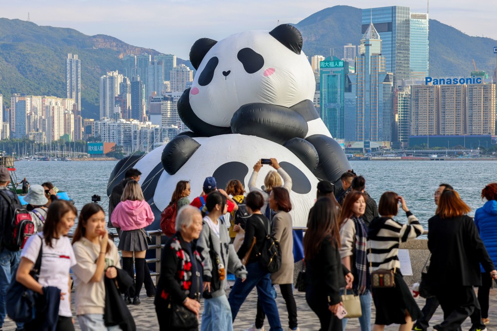 Tourists take photos with two giant inflatable giant pandas. Photo: Jelly Tse