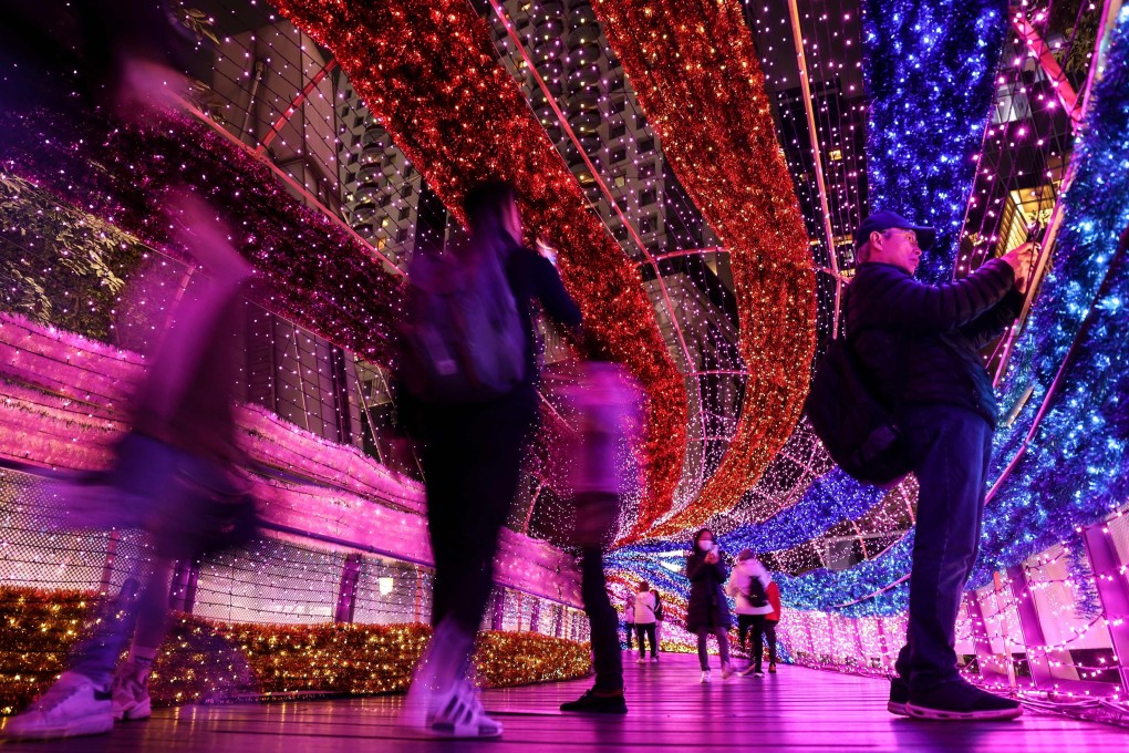 Visitors walk through a festive light tunnel in New Taipei City on Christmas Eve. From January 1, Taiwan will be issuing six-month visas to “digital nomads” to lure more foreigners to the island. Photo: AFP
