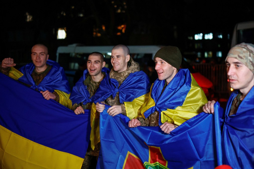 Ukrainian prisoners of war wrapped with national flags after their release. Photo: Reuters