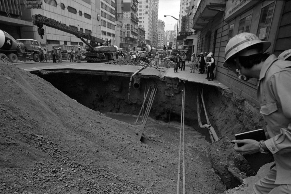 A worker inspects a gaping hole caused by a road collapse on Hennessy Road, Hong Kong, in 1983. Photo: Sunny Lee