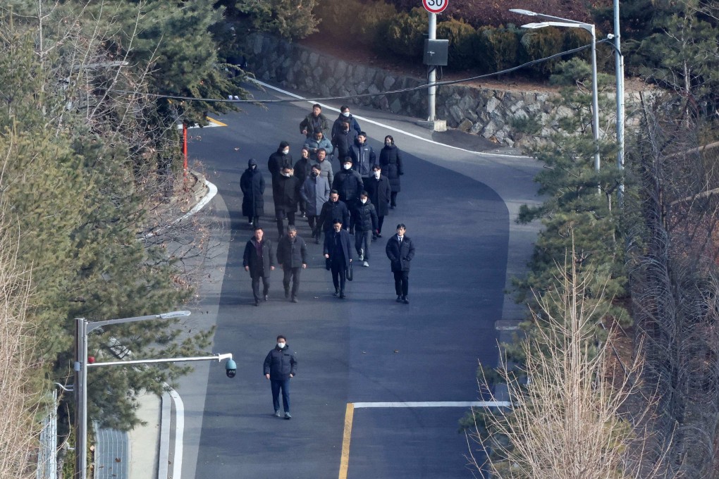 Investigators and police officers leave South Korean President Yoon Suk-yeol’s residence in Seoul on Friday. Photo: AFP