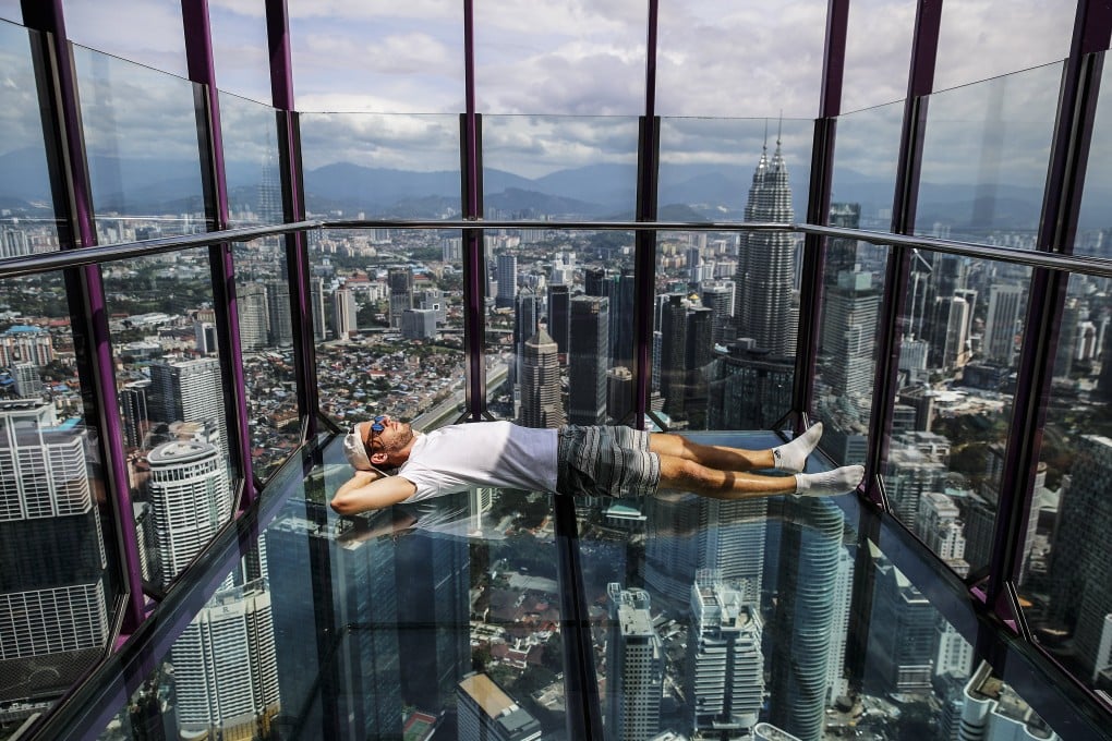 A visitor lies down in Kuala Lumpur Tower’s “Sky Box”, one of the city’s most popular tourist attractions, in Kuala Lumpur, Malaysia, in January 2024. Photo: EPA-EFE