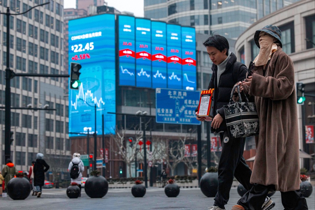 People walk on the street near a large screen showing stock and index levels in Shanghai in February 2024. Photo: EPA-EFE