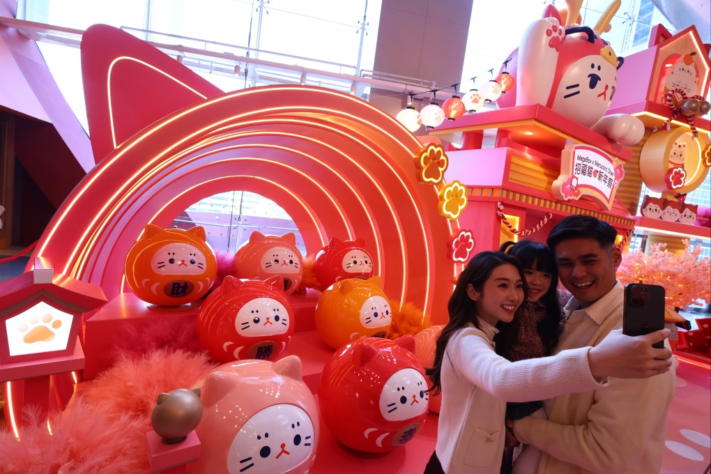 A family poses for a photo with a Lunar New Year installation at MegaBox shopping centre. Photo: Dickson Lee