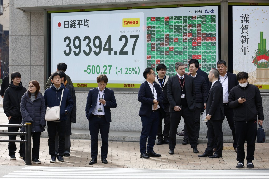 Passersby stand before an electronic board showing stock market indicators in Tokyo on January 6, the first day of trading in 2025: Photo: EPA-EFE