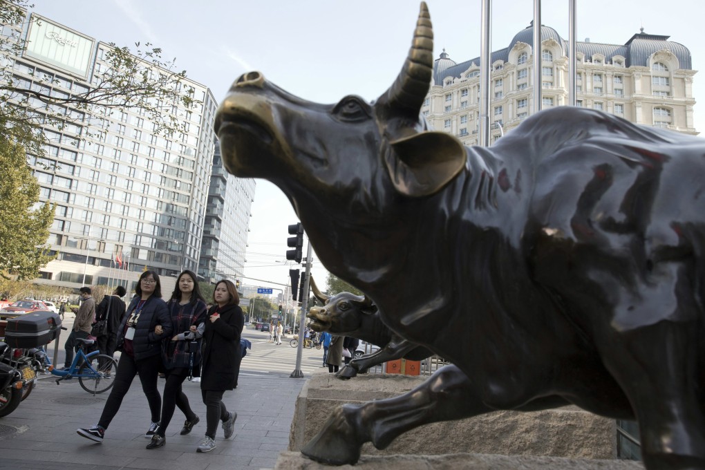 Pedestrians pass a statue of a bull in Beijing on November 8, 2017. Photo: AP