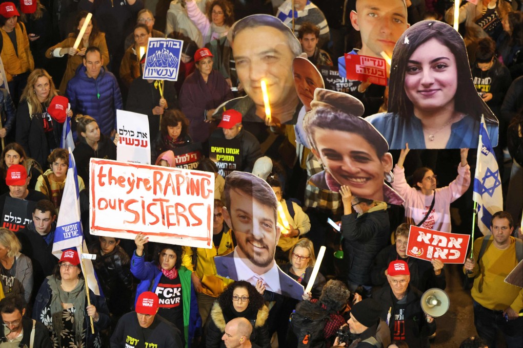 Protesters hold candles and cutout portraits of hostages held captive in Gaza during a demonstration in Tel Aviv on Saturday. Photo: AFP
