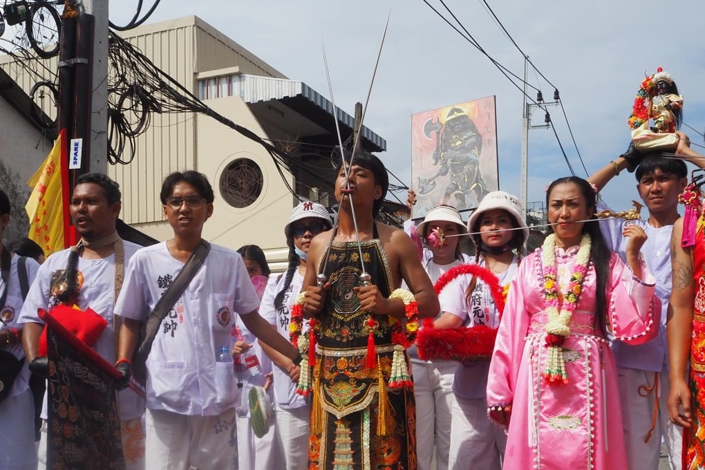 A spiritual medium with spikes through his cheeks walks in a parade during Phuket’s Vegetarian Festival, a Taoist event that promotes purification. Photo: Philipp Meier