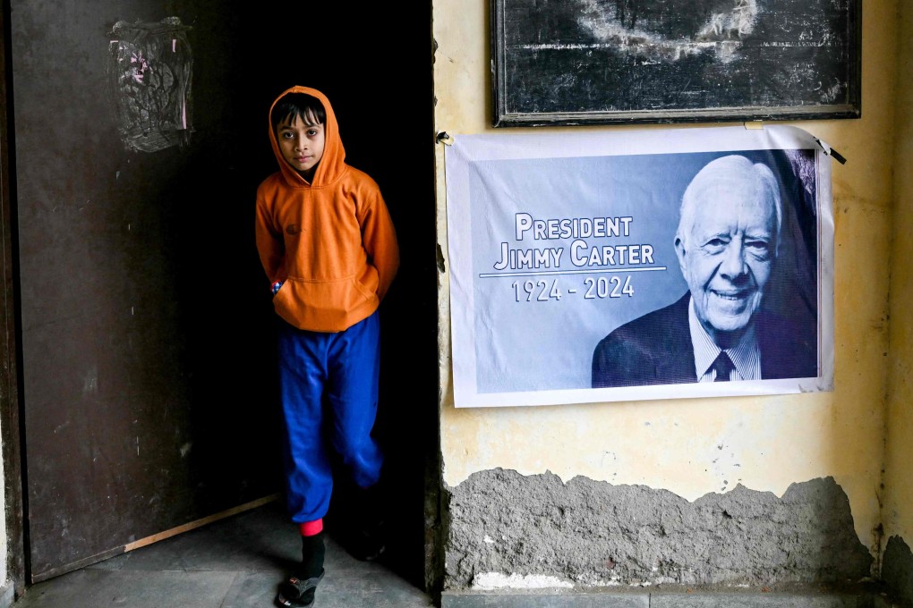 A poster in the memory of late former US president Jimmy Carter, is displayed at a community center in the eponymous Carterpuri village of Gurgaon on January 7, 2025. Photo: AFP