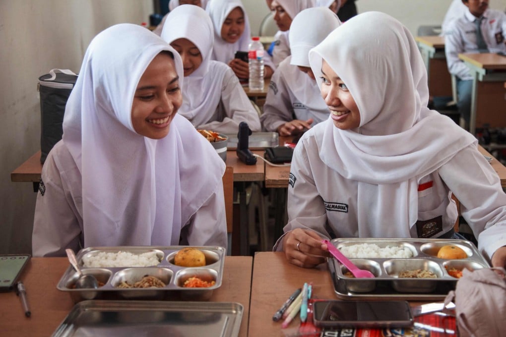 Students receive their lunches on the first day of a free-meal programme at a high school in East Jakarta on Monday. Photo: AFP