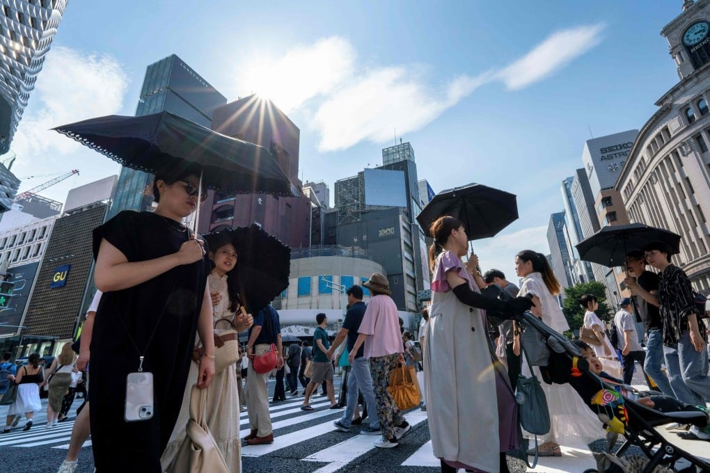 Pedestrians use umbrellas to shade themselves from the sun on a hot day in Tokyo last July. Photo: AFP