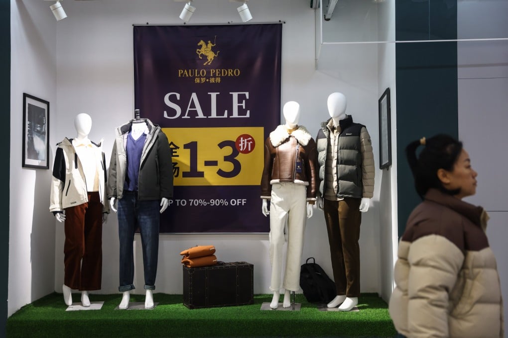 A woman walks past a clothing shop in Beijing last month. Photo: EPA-EFE