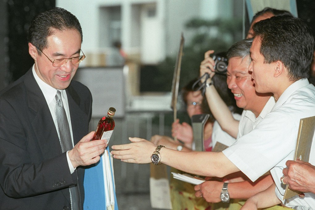 Executive council member Henry Tang is handed a bottle of Chinese medicinal wine by workers at a local production plant in 1998. Photo: SCMP Archives