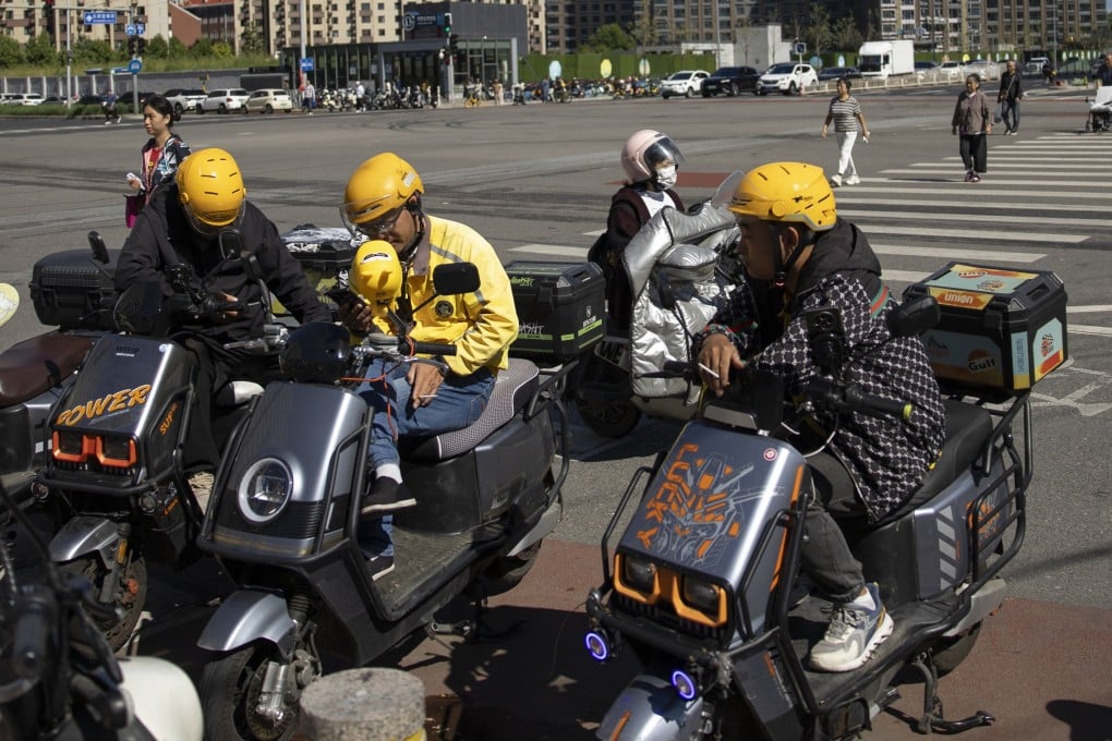 Delivery drivers sit on electric scooters in Beijing on September 14, 2024. Photo: EPA-EFE