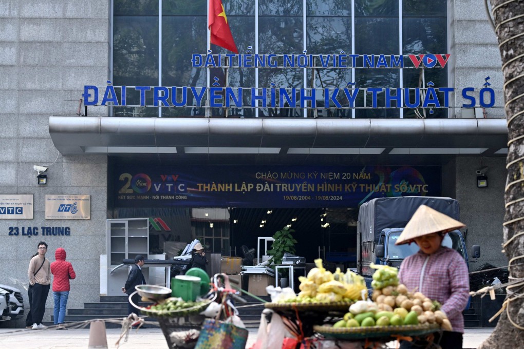 A fruit vendor waits for customers in front of the VTC office building in Hanoi on Wednesday. Photo: AFP