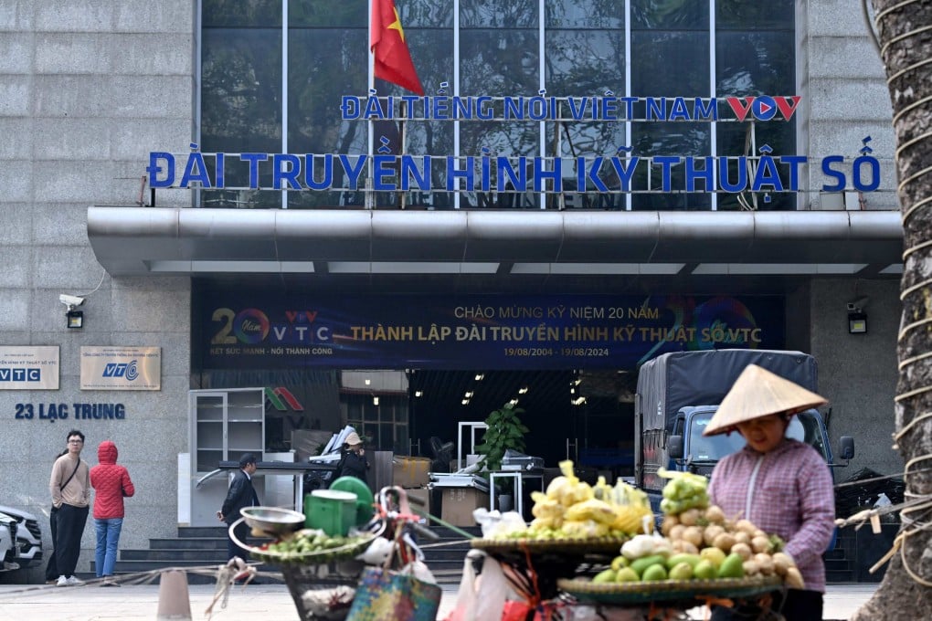 A fruit vendor waits for customers in front of the VTC office building in Hanoi on Wednesday. Photo: AFP