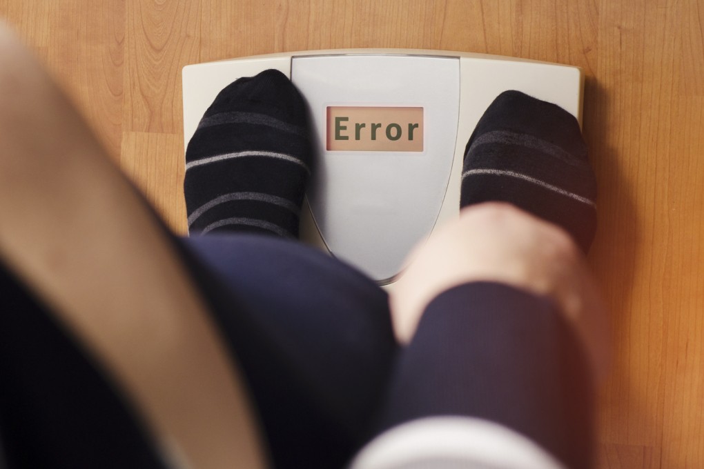 An overweight person standing on a digital weight scale. Photo: Shutterstock