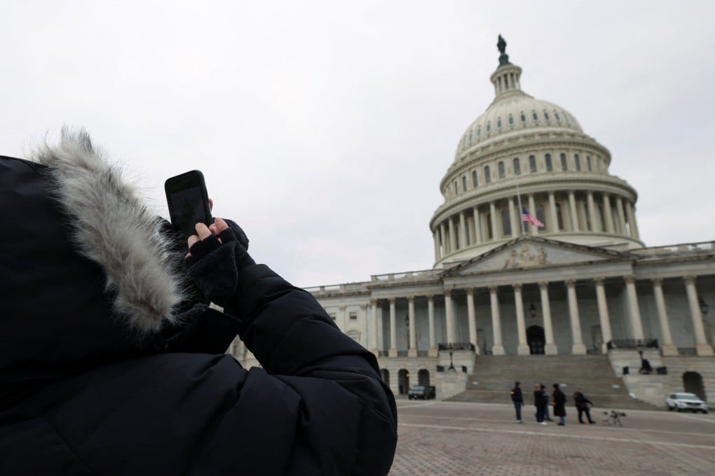 A women dressed in heavy winter clothing takes a picture of the US Capitol’s dome on Friday after it was announced that US president-elect Donald Trump’s inauguration is being moved indoors due to dangerously cold temperatures expected on Monday. Photo: Reuters