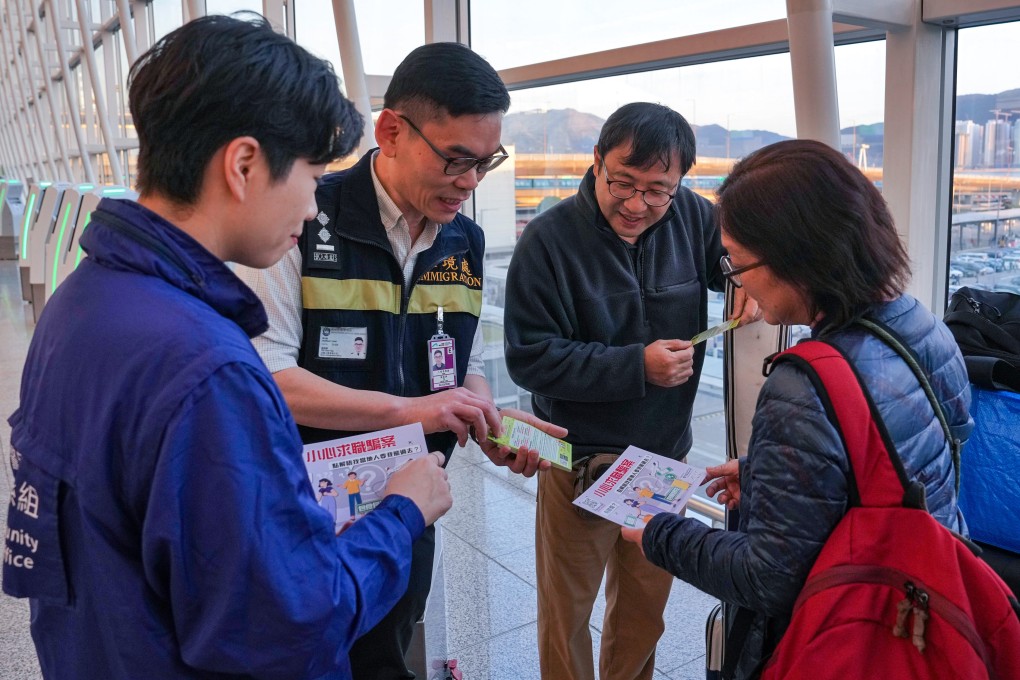 Police and Immigration Department officers distribute leaflets to travellers warning against job scams and human trafficking. Photo: Elson Li
