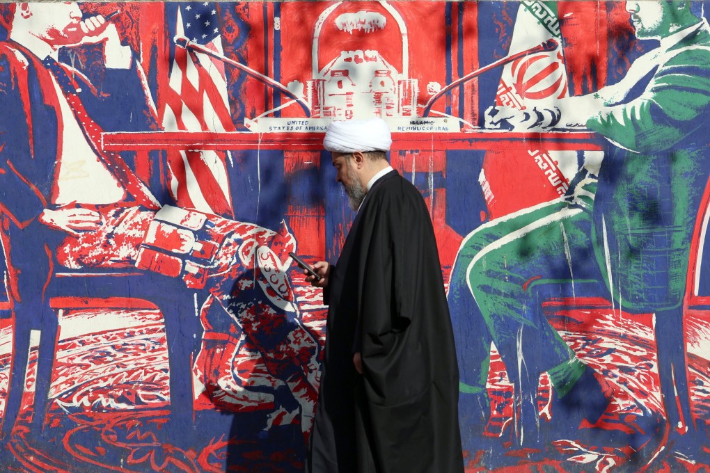 An Iranian cleric walks next to an anti-US mural in Tehran, Iran, on Wednesday. Photo: EPA-EFE