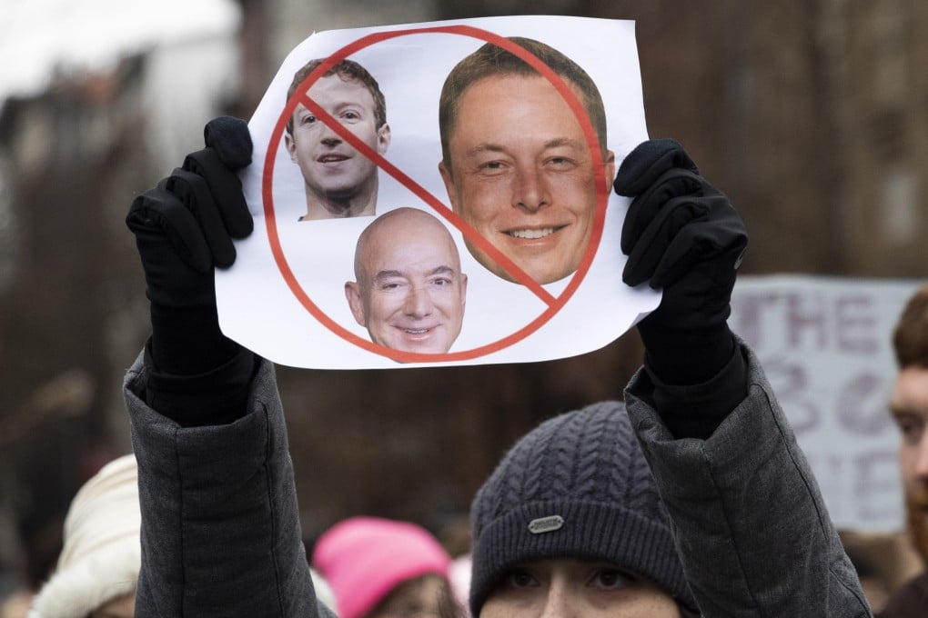 A protester holds a sign with the faces of Elon Musk, Mark Zuckerberg and Jeff Bezos at a rally in Washington to protest the policies of the incoming Trump administration. Photo: Gina M Randazzo/ZUMA Press Wire/dpa