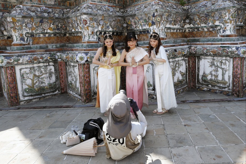 Chinese tourists do a Thai traditional greeting while posing for photographs at the Temple of Dawn, or Wat Arun, in Bangkok, Thailand, earlier in January. Photo: EPA-EFE