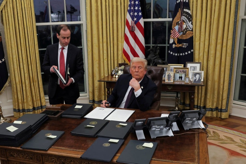 US President Donald Trump signs documents as he issues executive orders, in the Oval Office on Monday, his first day back in the White House. Photo: Reuters