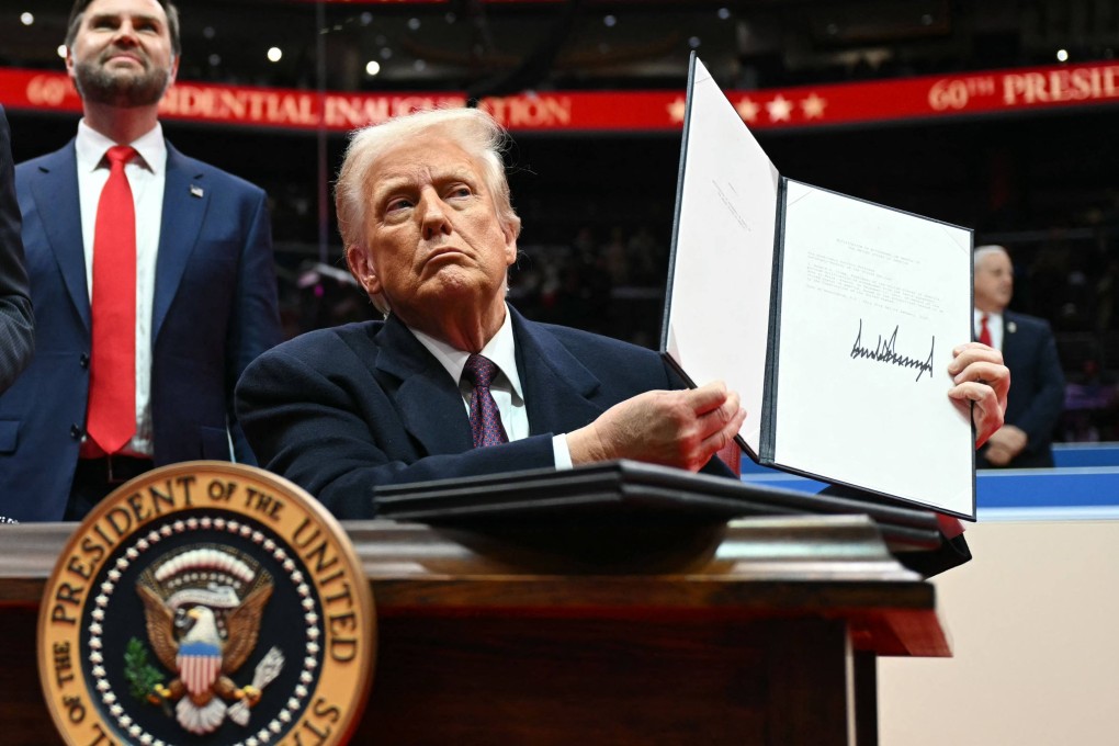 US President Donald Trump holds up a letter to the UN stating that the US will withdraw from the Paris Agreement during his inaugural parade inside Capital One Arena, in Washington on Monday. Photo: AFP