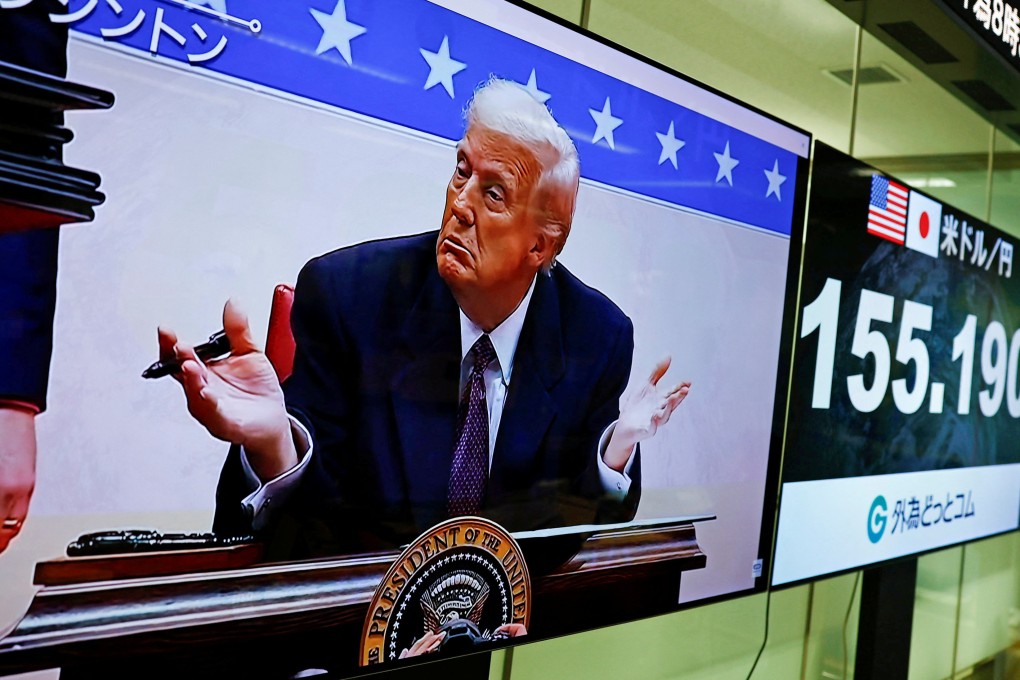 A screen shows live footage of US President Donald Trump signing executive orders next to monitors displaying the yen to dollar exchange rate at a foreign exchange trading company in Tokyo on Tuesday. Photo: Reuters