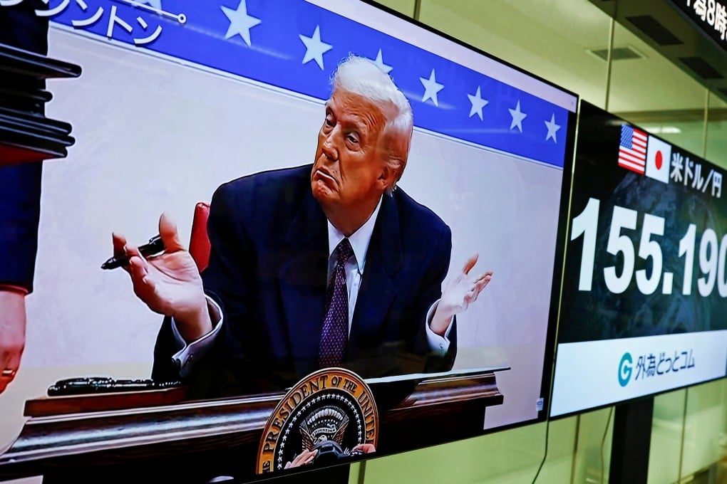 A screen shows live footage of US President Donald Trump signing executive orders next to monitors displaying the yen to dollar exchange rate at a foreign exchange trading company in Tokyo on Tuesday. Photo: Reuters