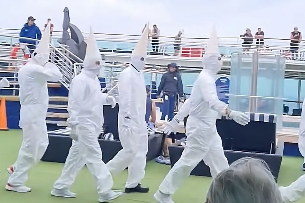 A still from a social media video shows staff strolling across the deck of an Australian cruise liner in all-white jumpsuits and cone-shaped hats evoking the distinctive white robes and masked hoods worn by the racist Ku Klux Klan. Photo: X/LidZen5